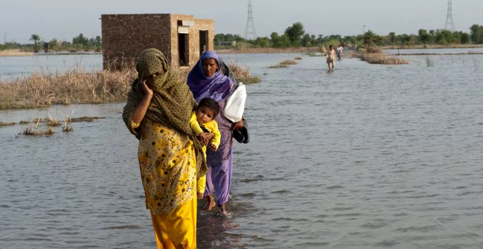 A family crosses the flooded streets of Pakistan.