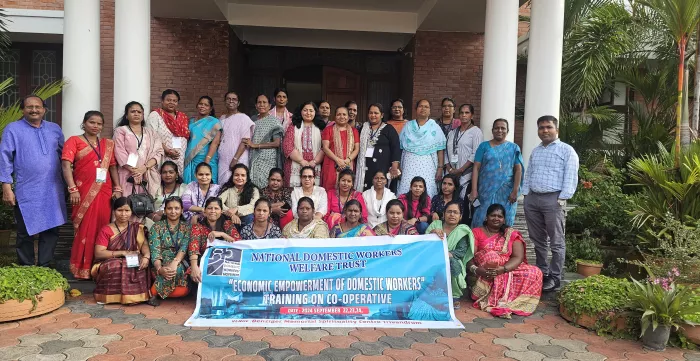 Men and women standing together with the event banner