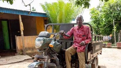 Cocoa farmer sitting on a motor tricycle in Côte d'Ivoire