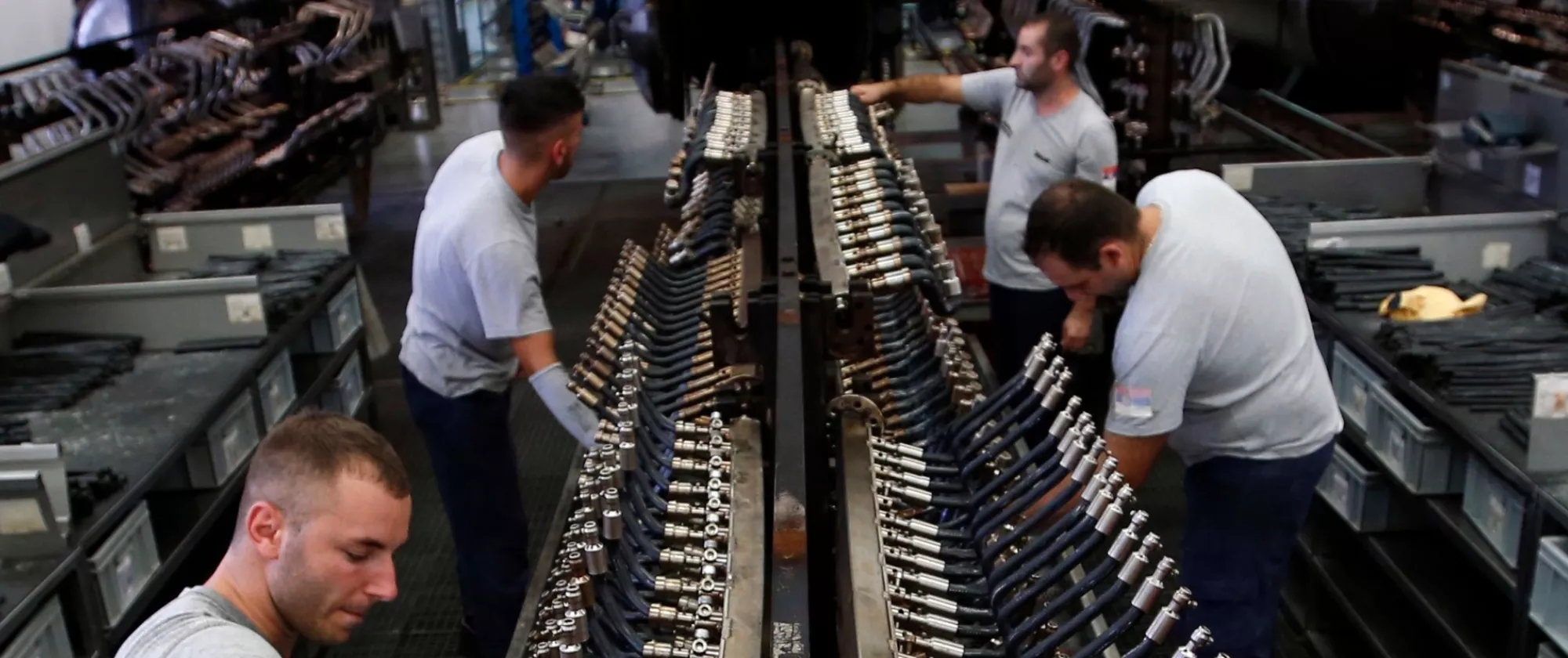 Decorative image featuring men at work on a production chain.