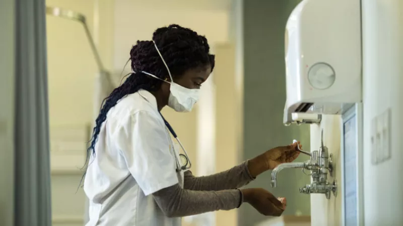 Nurse disinfects her hands